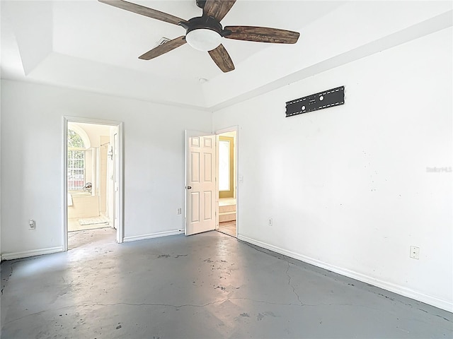 1332 Osceola Hollow Rd, Odessa, FL 33556 - unfurnished bedroom with baseboards, ensuite bathroom, concrete flooring, and a raised ceiling