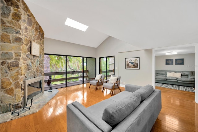 1111 N Bayshore Blvd Unit E10, Clearwater, FL 33759 - living room with high vaulted ceiling, a skylight, hardwood / wood-style flooring, and a stone fireplace