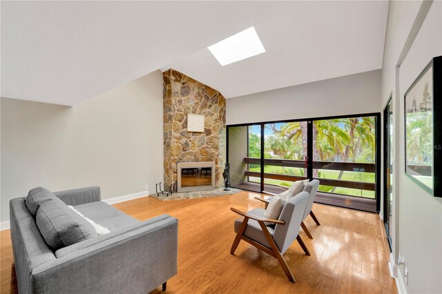 1111 N Bayshore Blvd Unit E10, Clearwater, FL 33759 - living area featuring a skylight, light wood-type flooring, a stone fireplace, and high vaulted ceiling