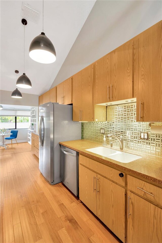1111 N Bayshore Blvd Unit E10, Clearwater, FL 33759 - kitchen with stainless steel appliances, light wood finished floors, backsplash, high vaulted ceiling, and pendant lighting