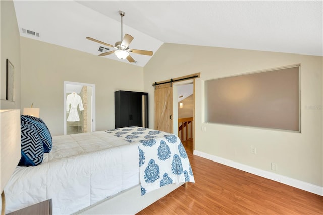 1111 N Bayshore Blvd Unit E10, Clearwater, FL 33759 - bedroom with vaulted ceiling, a barn door, wood finished floors, ceiling fan, and ensuite bathroom