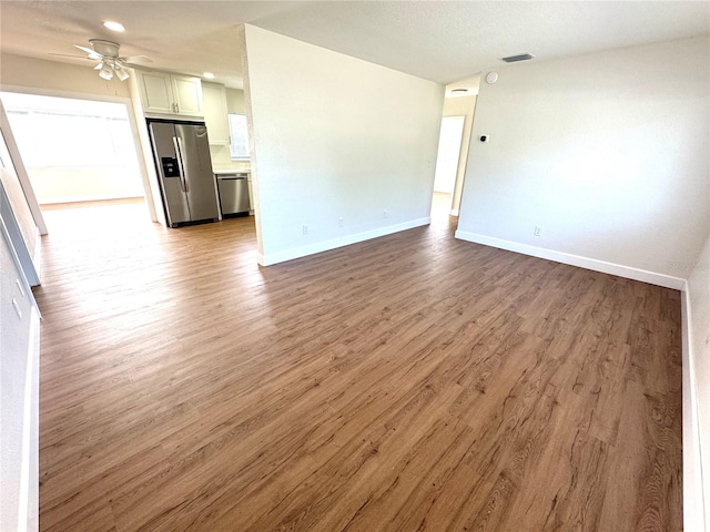 814 19th St SW, Largo, FL 33770 - unfurnished living room with wood finished floors, a ceiling fan, baseboards, and recessed lighting