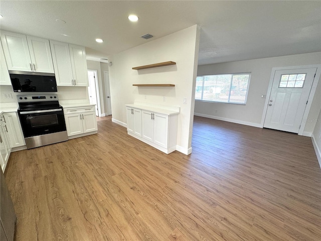 814 19th St SW, Largo, FL 33770 - kitchen featuring stainless steel appliances, light countertops, light wood-type flooring, white cabinetry, and recessed lighting