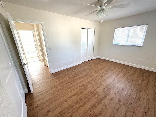 814 19th St SW, Largo, FL 33770 - unfurnished bedroom with wood finished floors, baseboards, a closet, and a ceiling fan