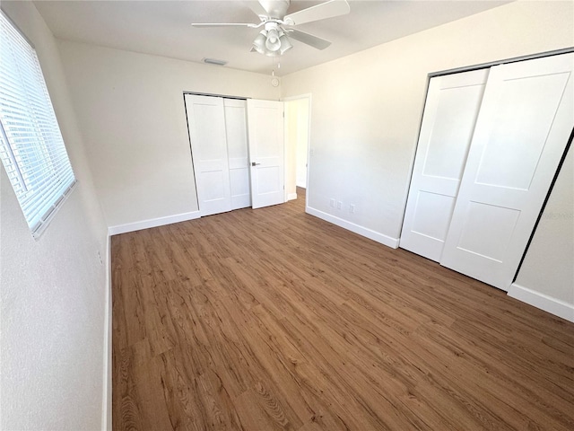 814 19th St SW, Largo, FL 33770 - unfurnished bedroom featuring wood finished floors, baseboards, ceiling fan, and multiple closets