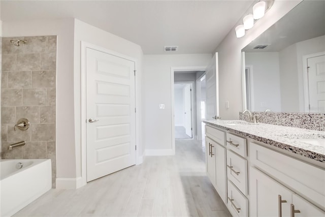 16433 66th Ln E, Parrish, FL 34219 - full bathroom with double vanity, wood finished floors, baseboards, and shower / washtub combination