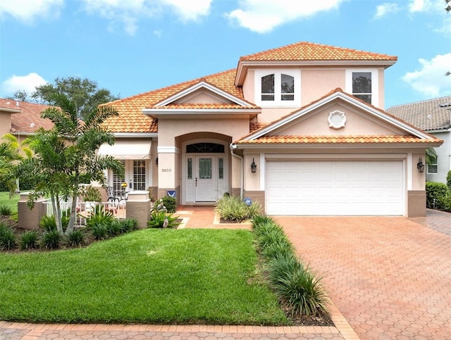 9800 Sago Point Dr, Seminole, FL 33777 - mediterranean / spanish-style home with stucco siding, decorative driveway, a front lawn, a tile roof, and a garage