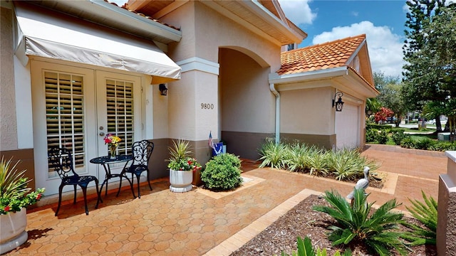 9800 Sago Point Dr, Seminole, FL 33777 - doorway to property with a tile roof, stucco siding, and a garage