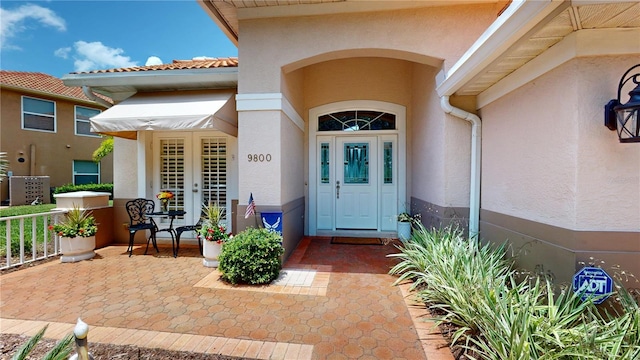 9800 Sago Point Dr, Seminole, FL 33777 - doorway to property with stucco siding and french doors