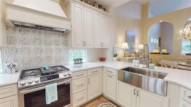 9800 Sago Point Dr, Seminole, FL 33777 - kitchen with gas stove, custom exhaust hood, a sink, light countertops, and decorative backsplash