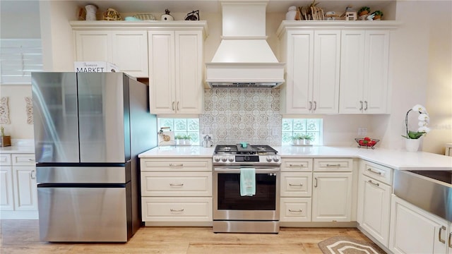 9800 Sago Point Dr, Seminole, FL 33777 - kitchen featuring stainless steel appliances, custom range hood, light countertops, and white cabinets