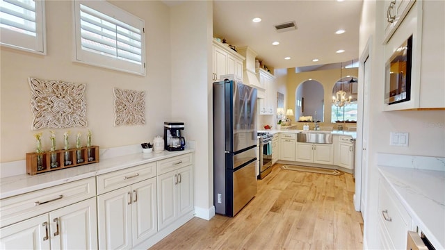 9800 Sago Point Dr, Seminole, FL 33777 - kitchen with stainless steel appliances, a chandelier, light wood-style floors, plenty of natural light, and recessed lighting