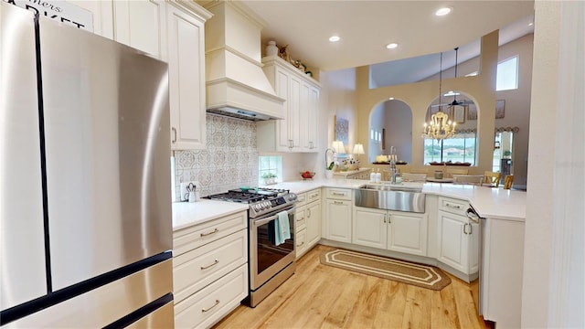 9800 Sago Point Dr, Seminole, FL 33777 - kitchen with stainless steel appliances, custom range hood, a chandelier, a sink, and healthy amount of natural light