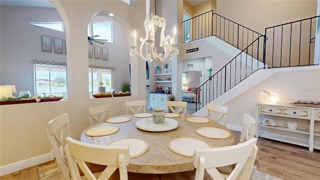 9800 Sago Point Dr, Seminole, FL 33777 - dining room with a high ceiling, stairway, a ceiling fan, wood finished floors, and a chandelier