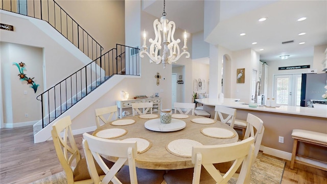 9800 Sago Point Dr, Seminole, FL 33777 - dining room with light wood finished floors, stairway, a chandelier, baseboards, and a high ceiling