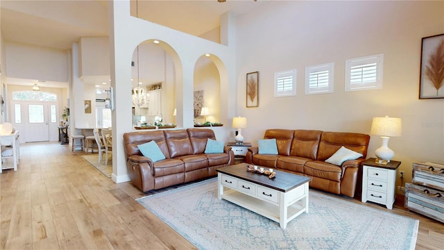 9800 Sago Point Dr, Seminole, FL 33777 - living area featuring a towering ceiling, light wood-type flooring, and a chandelier