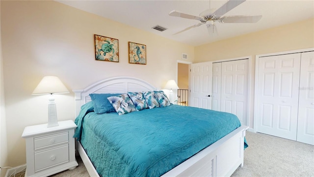 9800 Sago Point Dr, Seminole, FL 33777 - bedroom featuring light carpet, multiple closets, and a ceiling fan