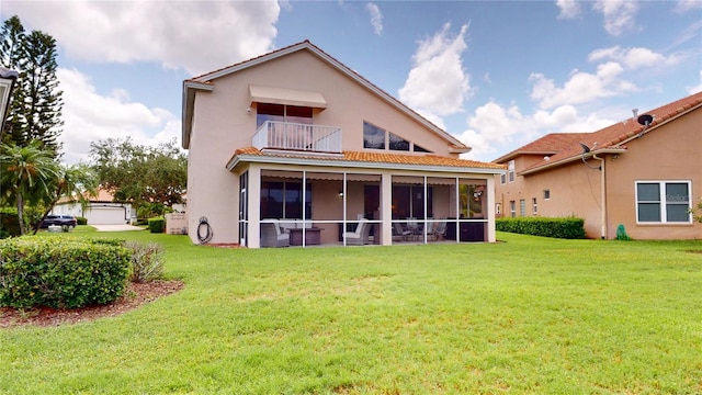 9800 Sago Point Dr, Seminole, FL 33777 - rear view of property featuring a balcony, a lawn, stucco siding, a tile roof, and a sunroom