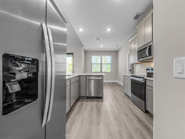 5104 Munhal St, Port Charlotte, FL 33981 - kitchen featuring stainless steel appliances, gray cabinets, a peninsula, light wood finished floors, and recessed lighting
