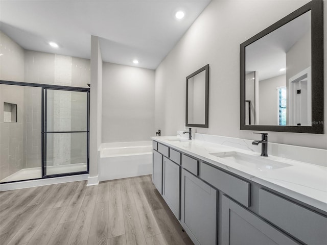 5104 Munhal St, Port Charlotte, FL 33981 - bathroom featuring a bath, double vanity, a stall shower, wood finished floors, and recessed lighting