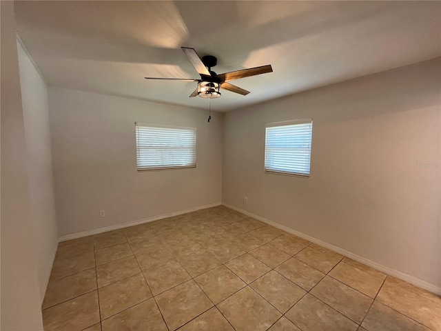422 Crosswinds Dr, Palm Harbor, FL 34683 - spare room featuring plenty of natural light, light tile patterned floors, a ceiling fan, and baseboards