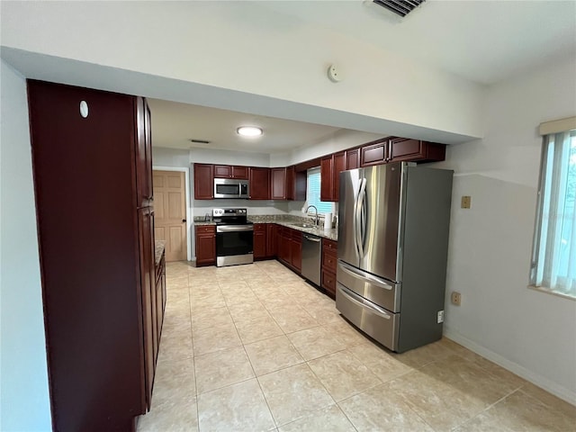 422 Crosswinds Dr, Palm Harbor, FL 34683 - kitchen with appliances with stainless steel finishes, light countertops, light tile patterned flooring, baseboards, and a sink