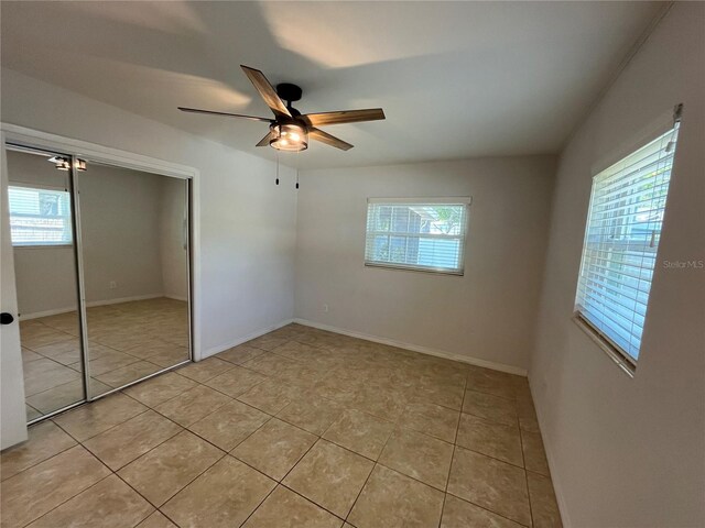 422 Crosswinds Dr, Palm Harbor, FL 34683 - unfurnished bedroom featuring multiple windows, light tile patterned floors, and a closet