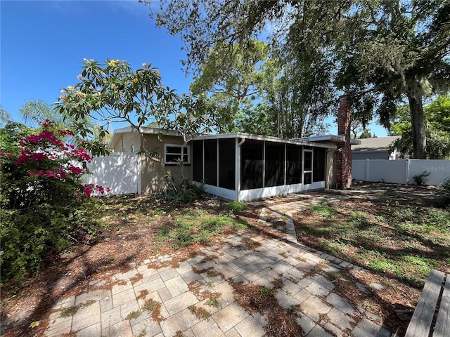 422 Crosswinds Dr, Palm Harbor, FL 34683 - back of property featuring a sunroom and a patio area