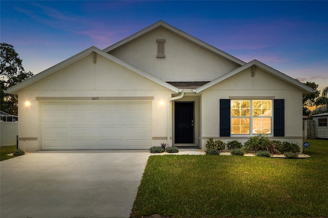10452 Elgin Blvd, Spring Hill, FL 34608 - view of front of property featuring a garage, concrete driveway, stucco siding, and a yard