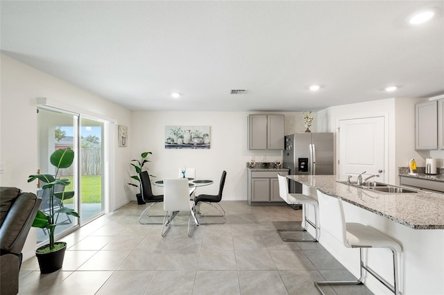 10452 Elgin Blvd, Spring Hill, FL 34608 - kitchen with gray cabinets, a sink, light stone counters, stainless steel fridge, and recessed lighting