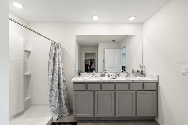 10452 Elgin Blvd, Spring Hill, FL 34608 - bathroom with curtained shower, double vanity, baseboards, recessed lighting, and a walk in closet