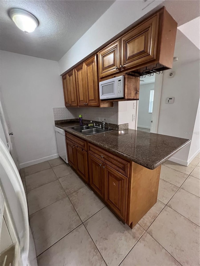 226 Thorn Tree Pl Unit 226, Brandon, FL 33510 - kitchen with white appliances, a sink, light tile patterned flooring, baseboards, and a textured ceiling