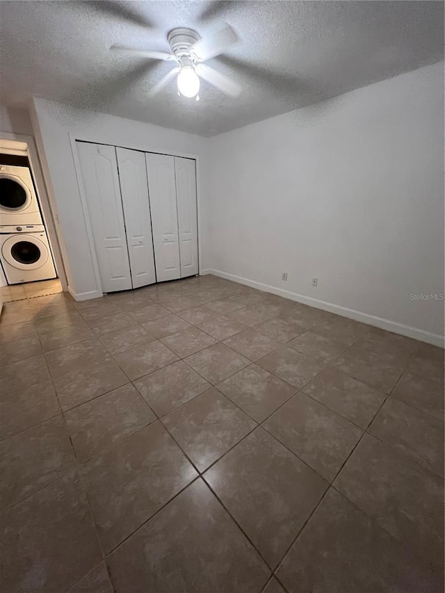 226 Thorn Tree Pl Unit 226, Brandon, FL 33510 - unfurnished bedroom with estacked washer and dryer, a textured ceiling, tile patterned flooring, a closet, and baseboards