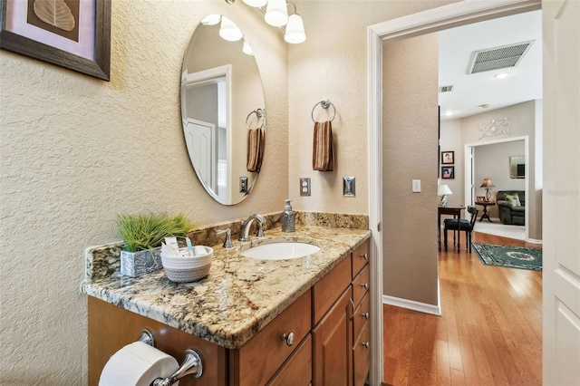 3484 Primrose Way, Palm Harbor, FL 34683 - bathroom featuring vanity, hardwood / wood-style floors, and a textured wall