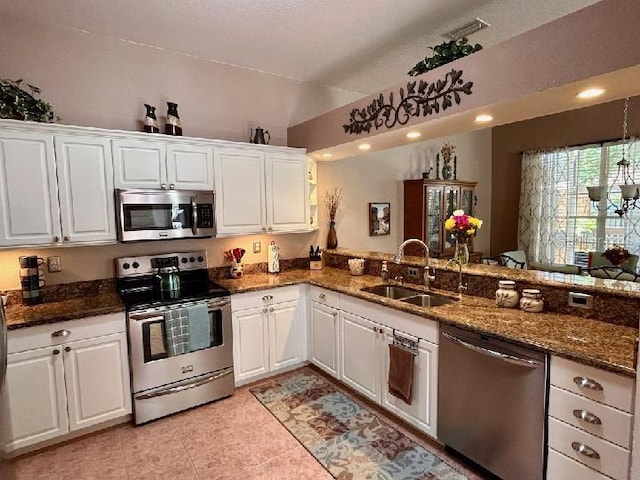 3484 Primrose Way, Palm Harbor, FL 34683 - kitchen featuring appliances with stainless steel finishes, white cabinets, dark stone countertops, light tile patterned floors, and lofted ceiling