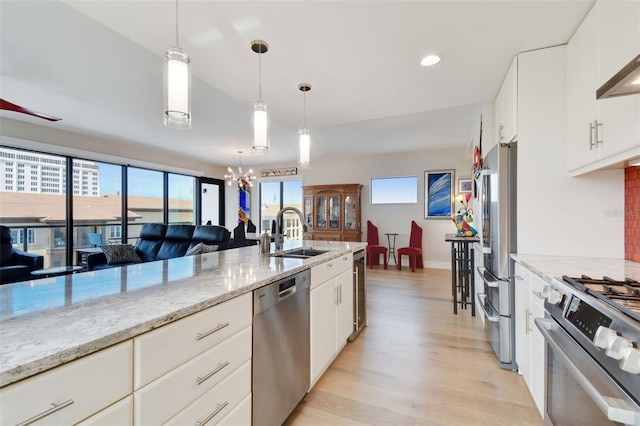 199 Dali Blvd Unit 607, Saint Petersburg, FL 33701 - kitchen with appliances with stainless steel finishes, a sink, light wood-type flooring, a chandelier, and hanging light fixtures