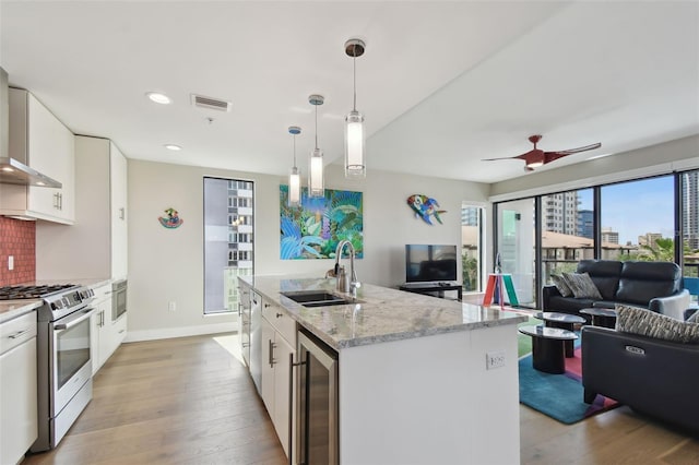 199 Dali Blvd Unit 607, Saint Petersburg, FL 33701 - kitchen featuring gas range, a sink, beverage cooler, open floor plan, and light wood-type flooring
