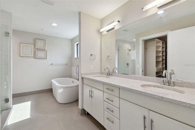 199 Dali Blvd Unit 607, Saint Petersburg, FL 33701 - full bathroom featuring a shower stall, double vanity, a walk in closet, a soaking tub, and baseboards