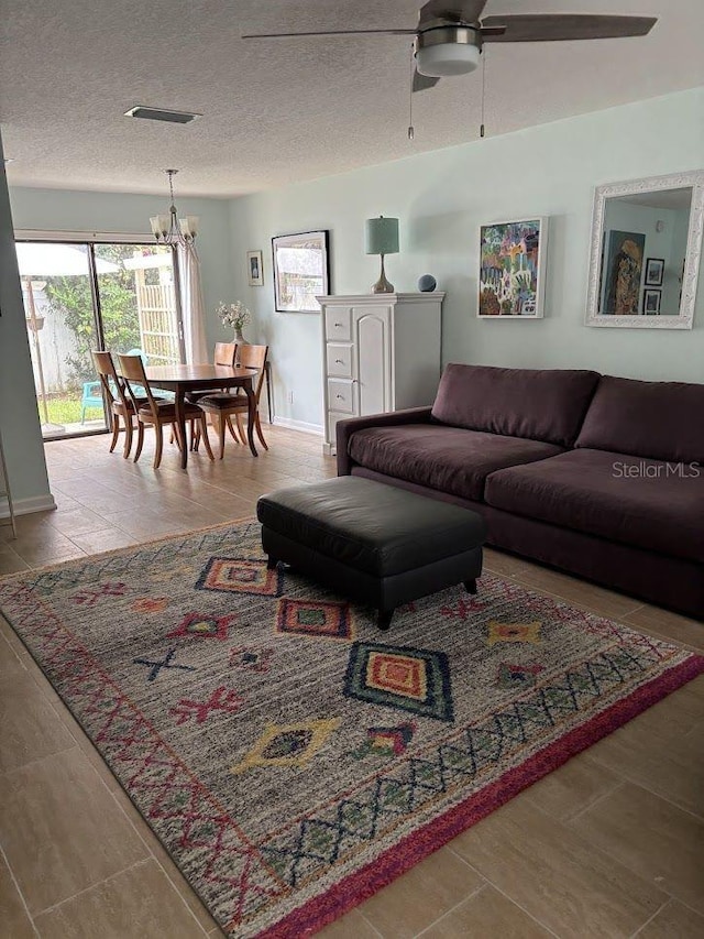 1055 6th Ave Unit A11, Vero Beach, FL 32960 - living room featuring a chandelier, a ceiling fan, baseboards, and a textured ceiling