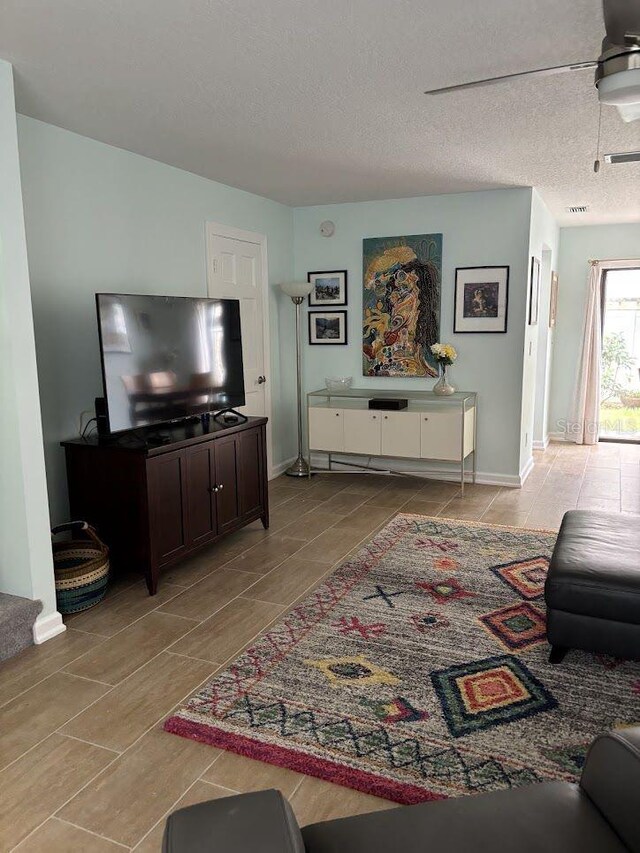 1055 6th Ave Unit A11, Vero Beach, FL 32960 - living room featuring light tile patterned floors, baseboards, and a textured ceiling