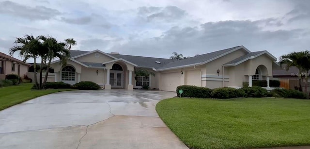2635 Jarvis Cir, Palm Harbor, FL 34683 - ranch-style home featuring french doors, driveway, stucco siding, and a front lawn