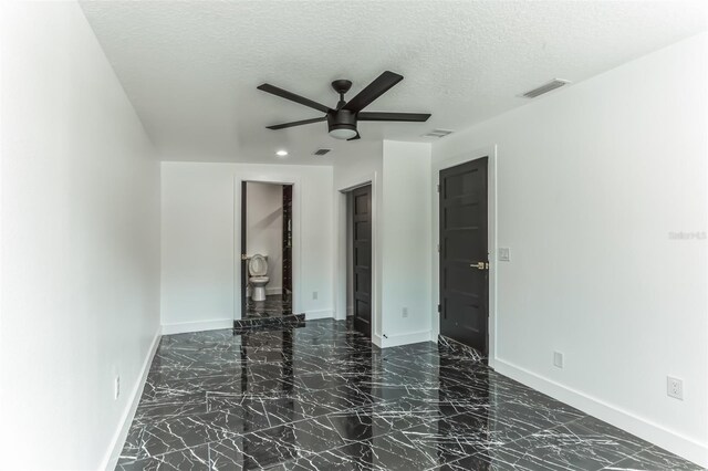 2010 4th Ave W, Palmetto, FL 34221 - empty room featuring baseboards, a ceiling fan, marble finish floors, and a textured ceiling