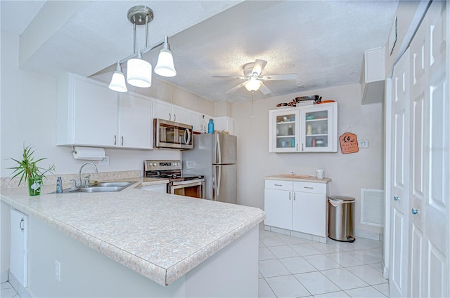 1655 S Highland Ave Unit B118, Clearwater, FL 33756 - kitchen featuring stainless steel appliances, a peninsula, light countertops, light tile patterned flooring, and a textured ceiling