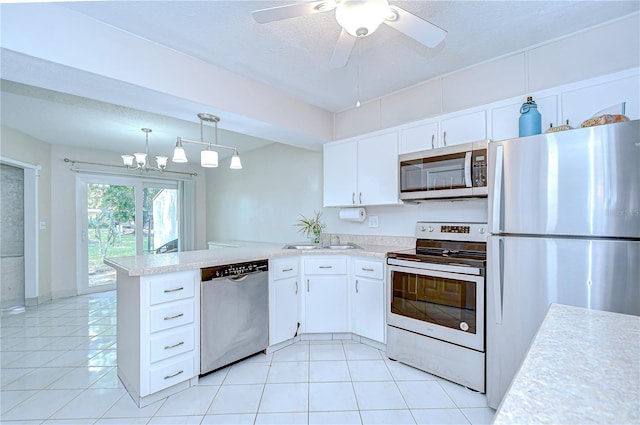 1655 S Highland Ave Unit B118, Clearwater, FL 33756 - kitchen with appliances with stainless steel finishes, light countertops, a peninsula, white cabinetry, and a textured ceiling