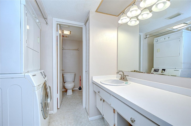 1655 S Highland Ave Unit B118, Clearwater, FL 33756 - full bath with stacked washer / dryer, tile patterned floors, vanity, a textured ceiling, and curtained shower