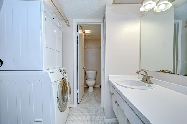 1655 S Highland Ave Unit B118, Clearwater, FL 33756 - bathroom featuring stacked washer / drying machine, vanity, tile patterned floors, and a textured ceiling