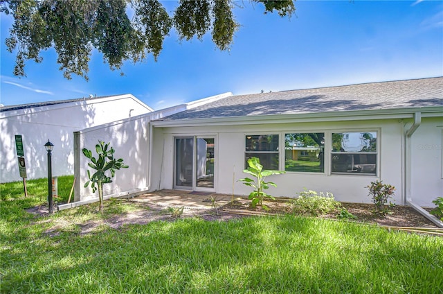 1655 S Highland Ave Unit B118, Clearwater, FL 33756 - rear view of house with roof with shingles, a yard, and stucco siding