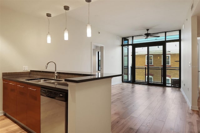 400 4th Ave S Unit 301, Saint Petersburg, FL 33701 - kitchen featuring stainless steel dishwasher, a sink, dark countertops, a wall of windows, and light wood-style flooring