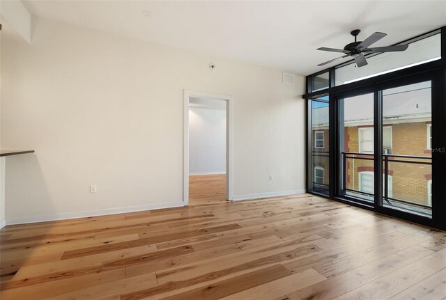 400 4th Ave S Unit 301, Saint Petersburg, FL 33701 - spare room featuring light wood finished floors, baseboards, a ceiling fan, and a wall of windows