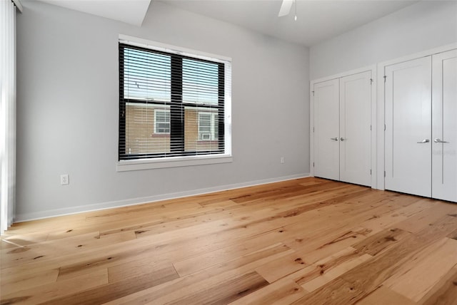 400 4th Ave S Unit 301, Saint Petersburg, FL 33701 - unfurnished bedroom featuring two closets, light wood-style floors, baseboards, and a ceiling fan
